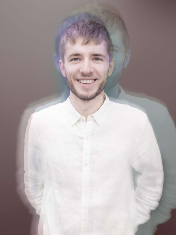 Friendly young man in white shirt, smiling towars the camera with white teeth